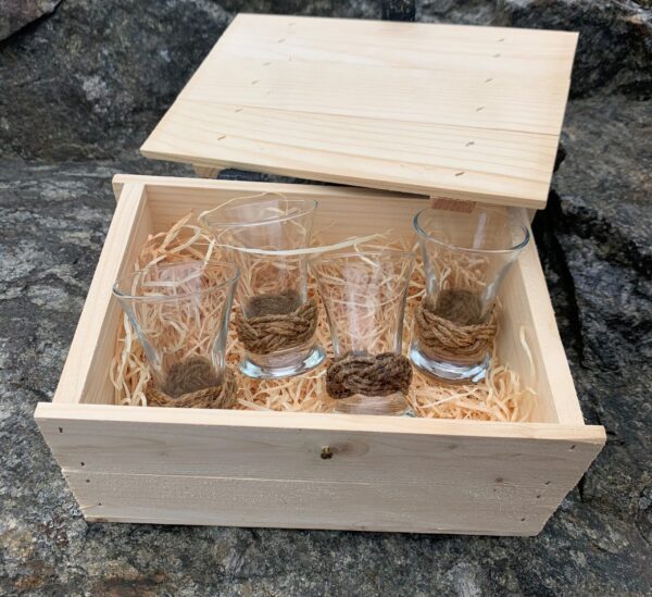 4 små glas med valknopar i en trälåda.